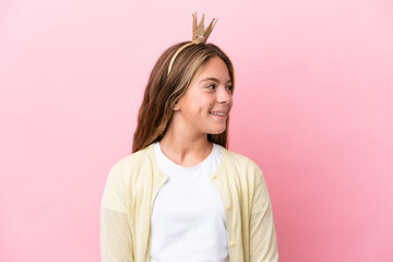 Fototapeta premium Little princess with crown isolated on pink background looking side