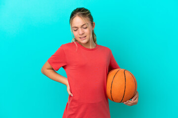 Little caucasian girl playing basketball isolated on blue background suffering from backache for having made an effort