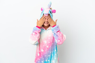 Little girl with unicorn pajamas isolated on white background covering eyes by hands