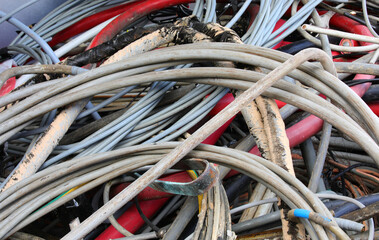 many used old electrical cords in a recycling container for copper recycling