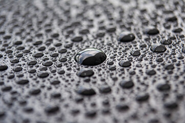 Close up of rain water droplets on dark cover background
