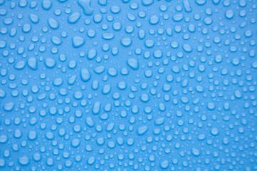 Close up of rain water droplets on blue cover background