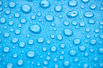 Close up of water droplets on blue cover background.