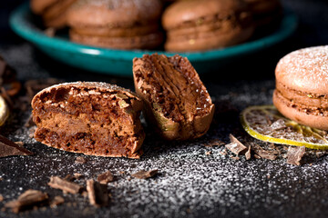 Macaroons with chocolate cream on a dark background