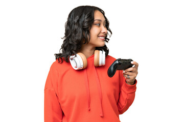 Young Argentinian woman playing with a video game controller over isolated background looking side