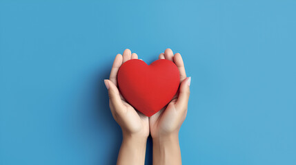 Obraz premium Hands hold a red heart on a blue background to represent love, romance and affection. 