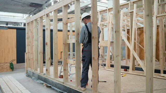 Worker carpenter assembling a modular house