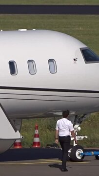 Corporate Jet with PIlot walking next to Aircraft at regional airport (white   unmarked   Business jet  private jet   executive jet)
