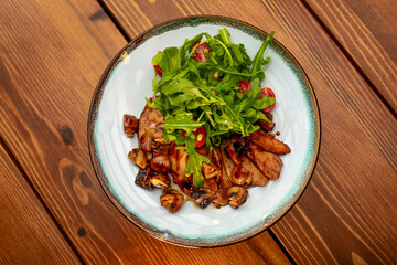 Salad of fried vegetables and mushrooms, eggplant, with fresh arugula and pine nuts. Vegetable salad with grilled champignons and cherry tomatoes. Healthy vegetarian food.