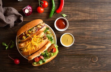 Hot dogs with different toppings on wooden background