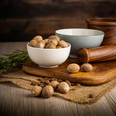 Nutmeg Whole on wooden table background. Herbs, spices and dried food baking ingredient. Mortar and different spices. Cottage kitchen. Product Photography