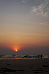 Fototapeta premium silhouette of a couple walking on the beach.