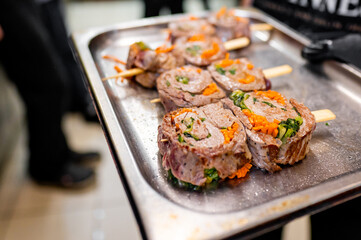 A tray with skewered rolled meat and vegetables, ready for cooking.