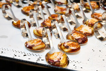 Catering tray with small designer spoons with octopus prepared G