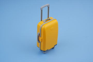 Orange suitcase on blue background. Travel concept.