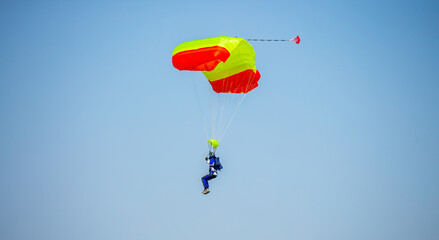 Skydiving. Flying parachutists against the background of the blue sky and mountains. Extreme sport and entertainment.