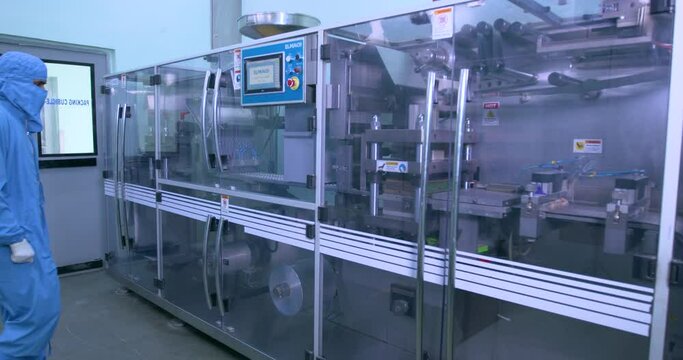 tablets making machine. automatic machine filling tablets in packing. pill making process in a pharma factory. medicine tablets moving in a machine. close up of tablet making process. pharma	
