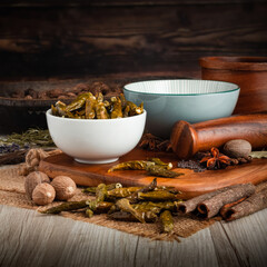 DRAGON GREEN DRIED CHILLI PODS on wooden table background. Herbs, spices and dried food baking ingredient. Mortar and different spices. Cottage kitchen. Product Photography