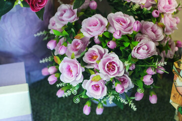There are several pink roses arranged on a table, creating a beautiful display