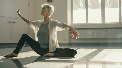 Elderly woman practicing yoga poses gently in a spacious fitness studio
