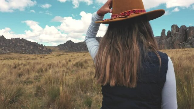 A woman traveling through the peruvian andes. Huayllay Stone Forest, Peru.