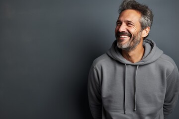 Obraz premium Portrait of a joyful man in his 40s dressed in a comfy fleece pullover isolated in bare monochromatic room