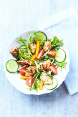 Healthy Salad with Grilled Chicken Briest, Cherry Tomatoes, Yellow Pepper, Cucumber and Endive. Bright wooden background. Top view	