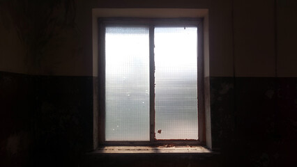 A bright window in a dark old shabby room.