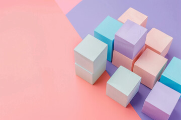 Obraz premium Soft pastel wooden blocks arranged on a peach and lavender backdrop, creating a minimalist and serene aesthetic.