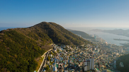 an aerial view of Busan, Korea, showcasing dense urban areas with numerous buildings, surrounded by...