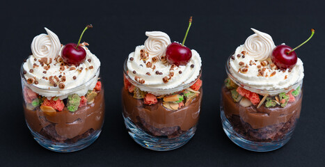 dessert in glass, layered with whipped cream and cherries, garnished with chocolate shavings