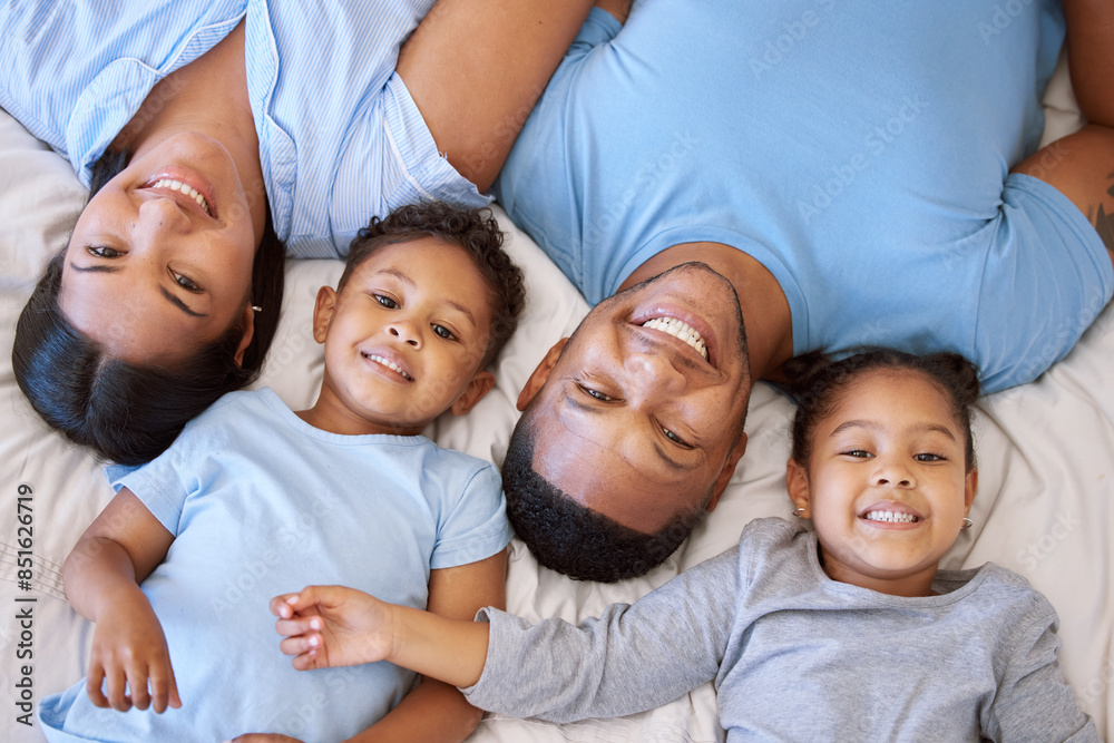 Wall mural Mexican family, top view and portrait on bed for love, smile and connect or security in home for bonding. Parents, children and relax in bedroom on morning for peace, wake up and together for support