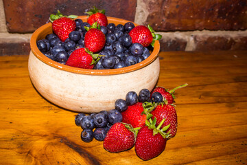 Rustic view of a bowl filled with sweet Strawberries and Blueberries
