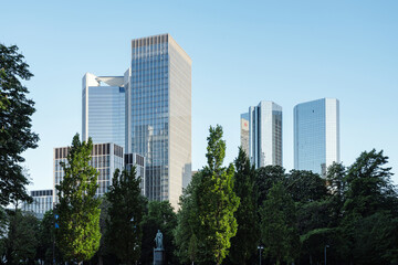 Fototapeta premium modern skyscrapers in a city, surrounded by lush green trees