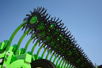 Close-up of a rotary harrow green color for processing an agricultural field. Against the...