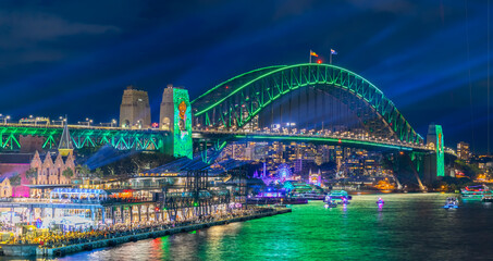 Obraz premium Colourful Light show at night on Sydney Harbour NSW Australia. The bridge illuminated with lasers and neon coloured lights 