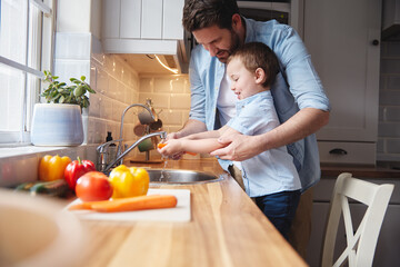 Kid, father and washing vegetables for cooking organic food, nutrition or learning healthy diet....