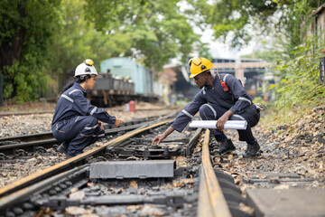 Railway Workers Discussing Plans on Railroad Track
