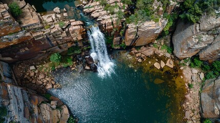 Overhead shot of a waterfall with white water plunging into a deep pool.