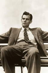 a man in suit sitting on bench