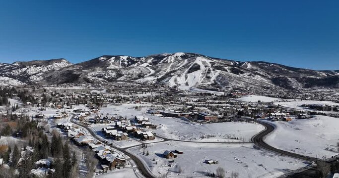 beautiful capture of mountain town with slopes in background and people enjoying their winter vacation in the mountains