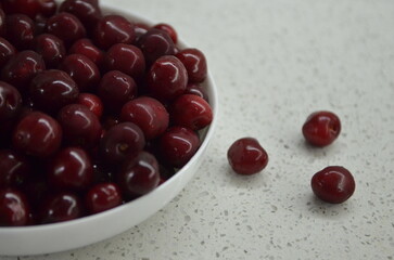 Red cherry in a bowl. Red sweet cherry background.
