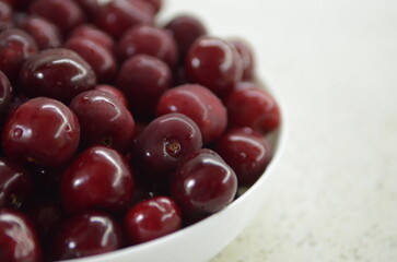 Red cherry in a bowl. Red sweet cherry background.