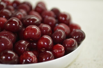 Red cherry in a bowl. Red sweet cherry background.