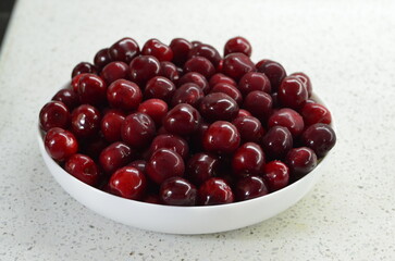 Red cherry in a bowl. Red sweet cherry background.