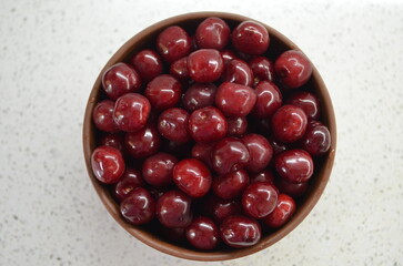 Red cherry in a bowl. Red sweet cherry background.