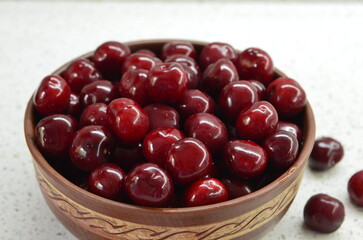 Red cherry in a bowl. Red sweet cherry background.