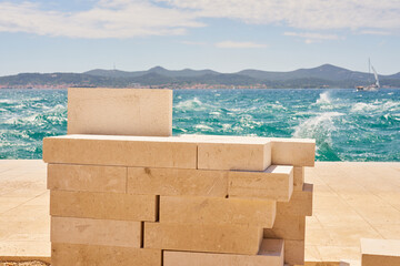 Granite tiles for laying a sidewalk with the sea in the background.