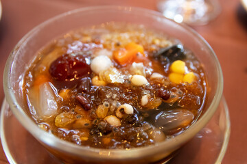 A delicious and refreshing bowl of shaved ice topped with sweet syrup, dried fruits, nuts, red beans and seeds.