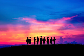 Fototapeta premium a group of graduates in graduation hats looking at the sunset, view from the back, appearance against the sky